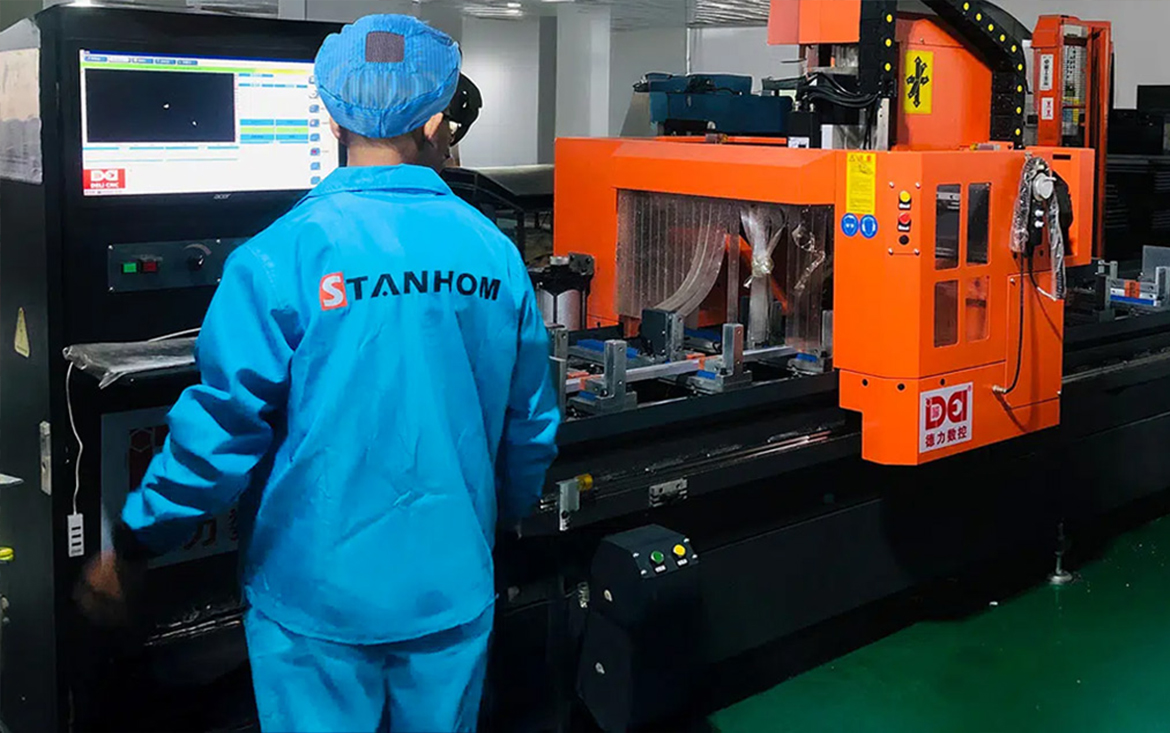 STANHOM operator working with aluminium mirror frame processing equipment STANHOM operator working with aluminium mirror frame processing equipment